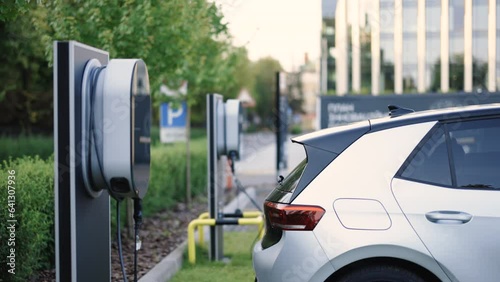 Charge station for electric cars. Electric car charger. Alternative energy for ecological cars. Electric, zero pollution cars on green energy concept on modern city parking lot