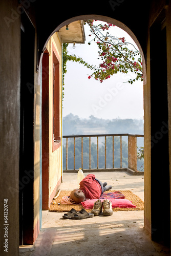 KATHMANDU, NEPAL: homeless person sleeping outside on the ground, Kopan Monastery photo