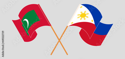 Crossed and waving flags of Maldives and the Philippines