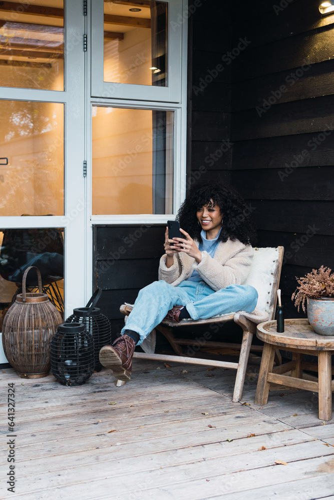 Obraz premium African stylish woman using smart phone