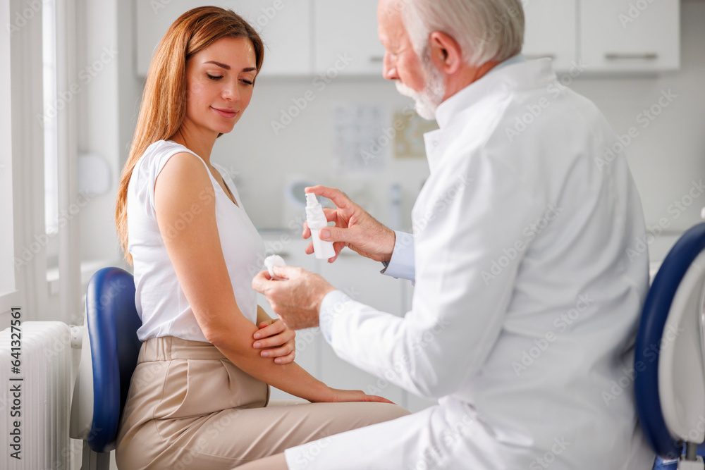 Fototapeta premium Doctor disinfecting patient's vaccine application spot