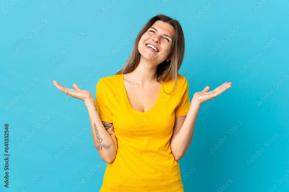 Young slovak woman isolated on blue background smiling a lot Young slovak woman isolated on blue background smiling a lot