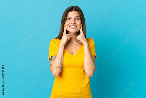 Young slovak woman isolated on blue background smiling with a happy and pleasant expression