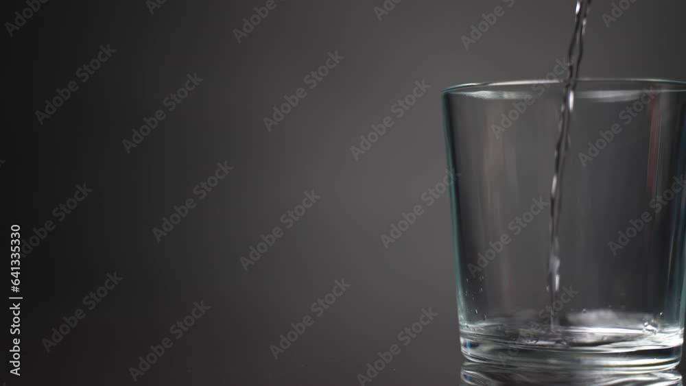 Pour water into a glass beaker. Slow motion Pour water into a glass beaker. Slow motion