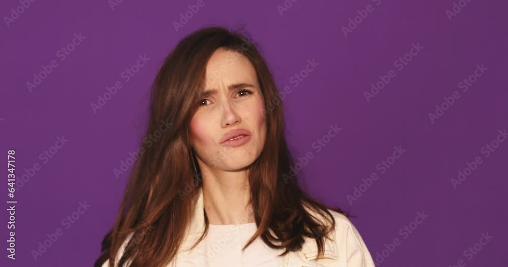 Side view of brunette young woman in denim jacket posing isolated on violet background in studio. Woman looking at camera found out heard good news, wow emotions Side view of brunette young woman in denim jacket posing isolated on violet background in studio. Woman looking at camera found out heard good news, wow emotions