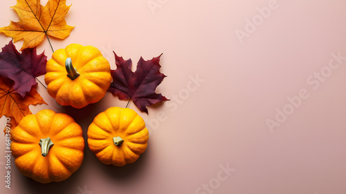 Autumn halloween composition with pumpkins and leaves on pink background. Flat lay, top view, copy space