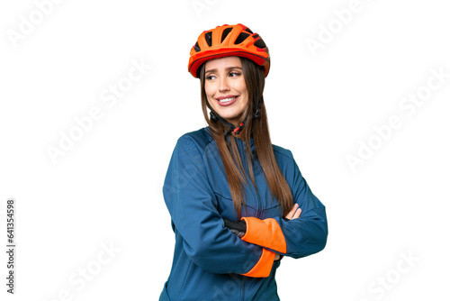 Young cyclist woman over isolated chroma key background with arms crossed and happy © luismolinero