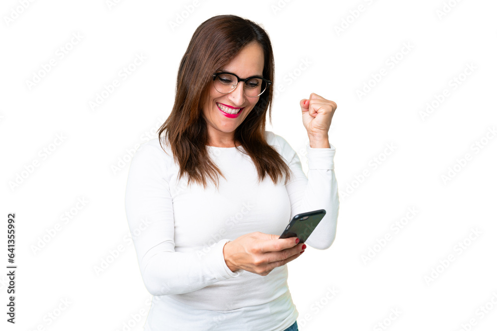 Middle age woman over isolated chroma key background with phone in victory position Middle age woman over isolated chroma key background with phone in victory position