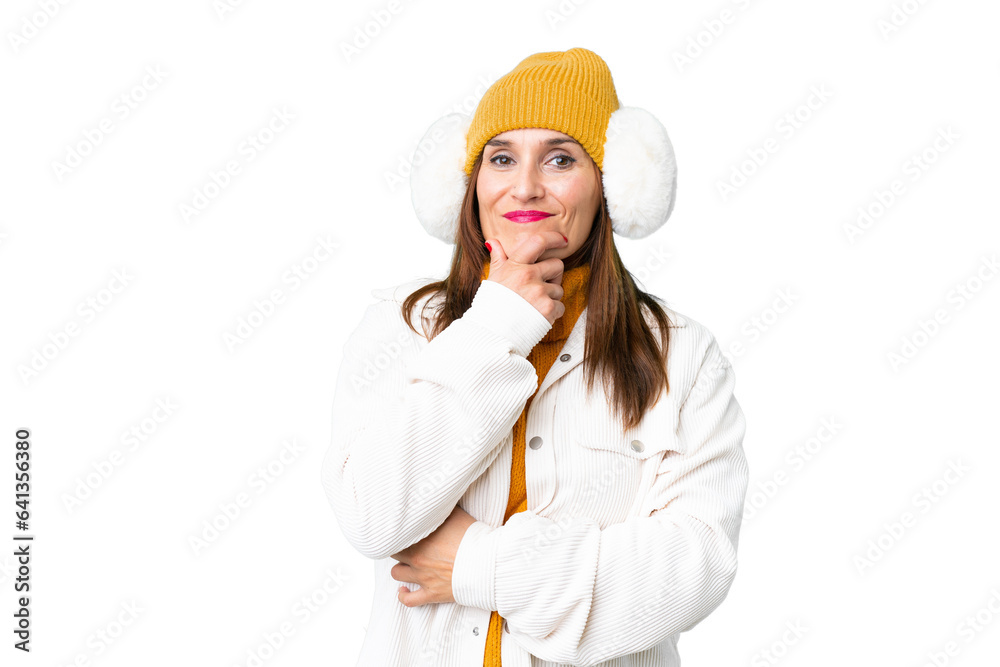 Middle age woman wearing winter muffs over isolated chroma key background smiling Middle age woman wearing winter muffs over isolated chroma key background smiling