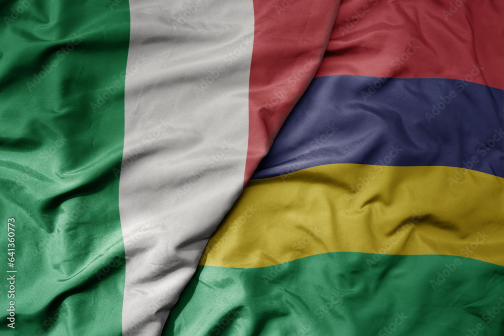 big waving national colorful flag of italy and national flag of mauritius .