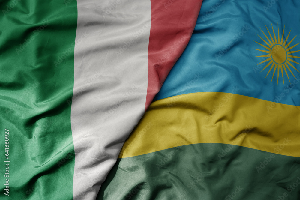big waving national colorful flag of italy and national flag of rwanda .