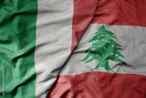 big waving national colorful flag of italy and national flag of lebanon . photo