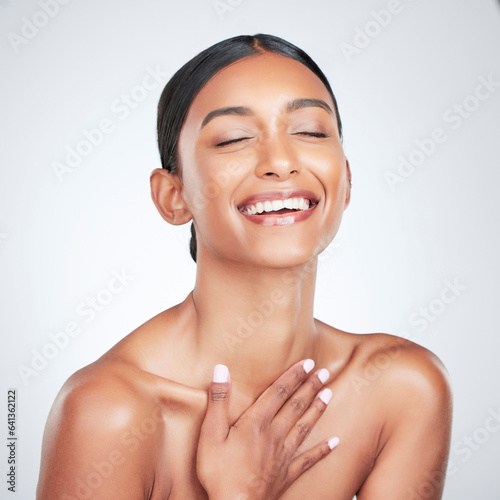 Face, beauty and smile with a woman laughing for health or wellness in studio on white background. Skincare, funny and cosmetics with a young model feeling happy or satisfaction about natural skin