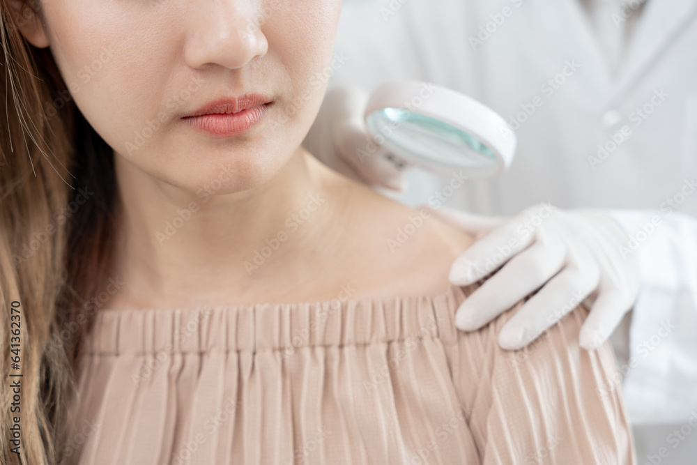 Naklejka premium skin problem and beauty of asian girl. Dermatologist use magnifying glass look itchy skin from skin allergic, steroid allergy, sensitive skin, chemical allergy, rash, insect bites, Dermatitis.