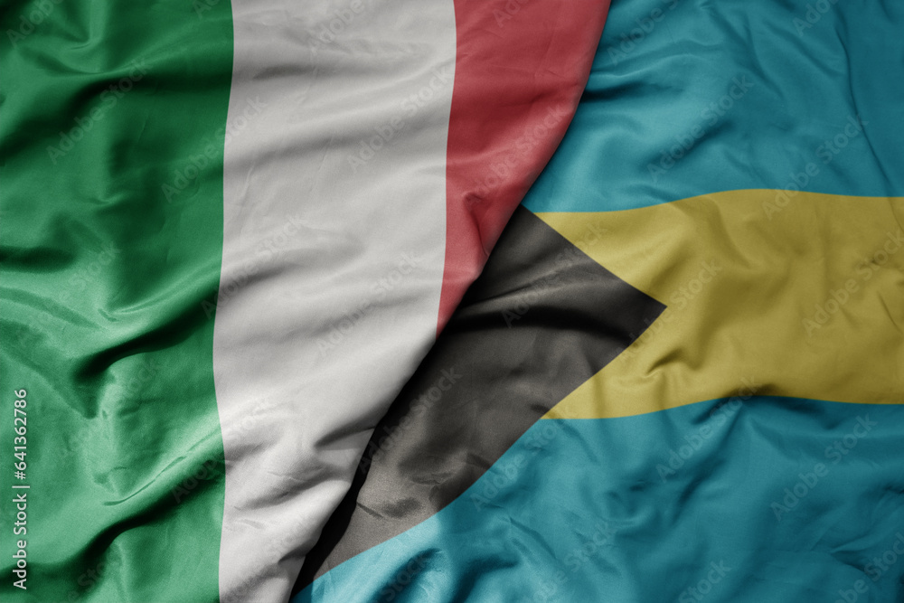 big waving national colorful flag of italy and national flag of bahamas .