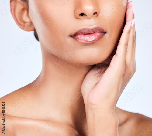 Woman, lips and beauty closeup with makeup, face and lipstick glow in studio. Mouth, skincare and hands of a female model with dermatology, wellness and facial with cosmetics and white background