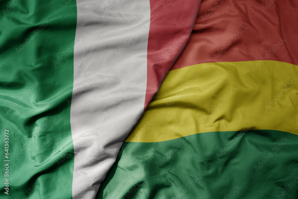 big waving national colorful flag of italy and national flag of bolivia .