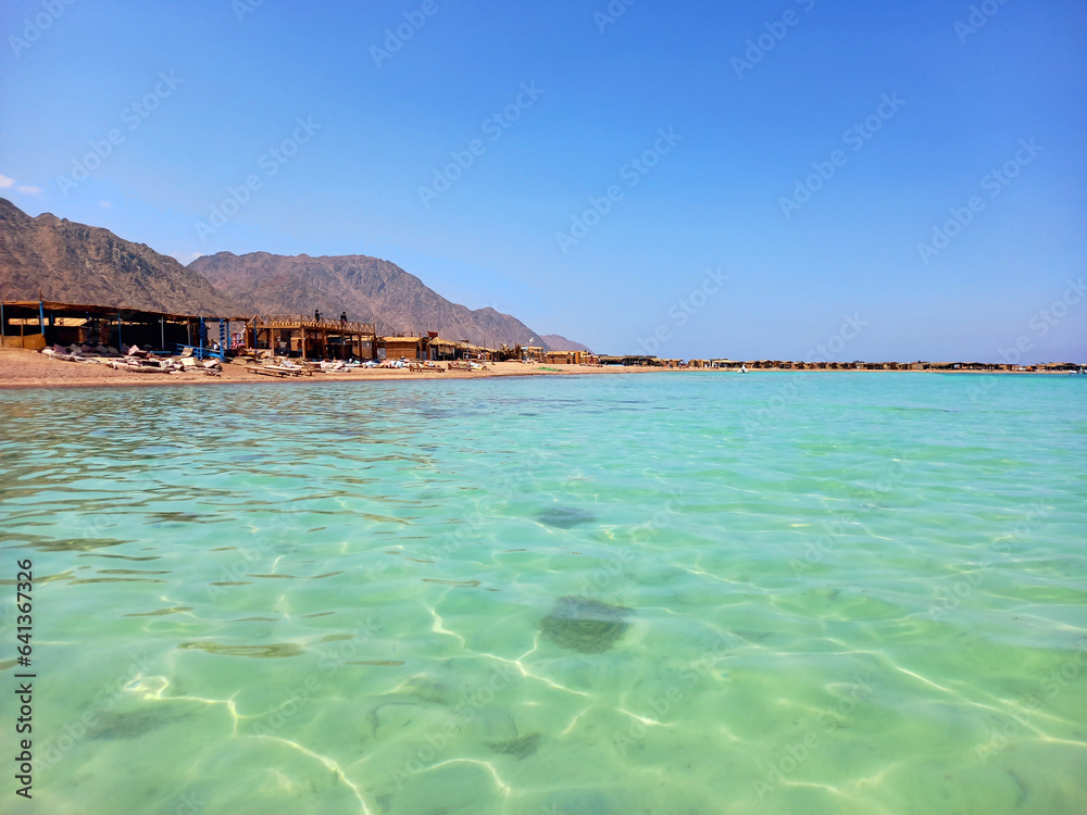 Panoramic view of turquoise waters of the Red Sea with Desert mountains. Extreme landscapes and vacation spots.