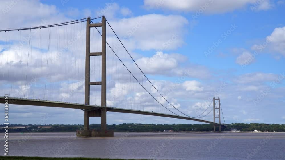Aerial drone view of Humber Bridge, 12th largest suspension span, gracefully crossing River Humber, connecting Lincolnshire to Humberside with traffic. Aerial drone view of Humber Bridge, 12th largest suspension span, gracefully crossing River Humber, connecting Lincolnshire to Humberside with traffic.