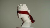 Closeup shot. Ancient marble bust statue of roman era woman blindfolded. Isolated on grey background.
