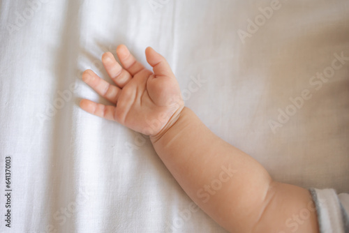 Tiny new born baby s arm closeup on light background