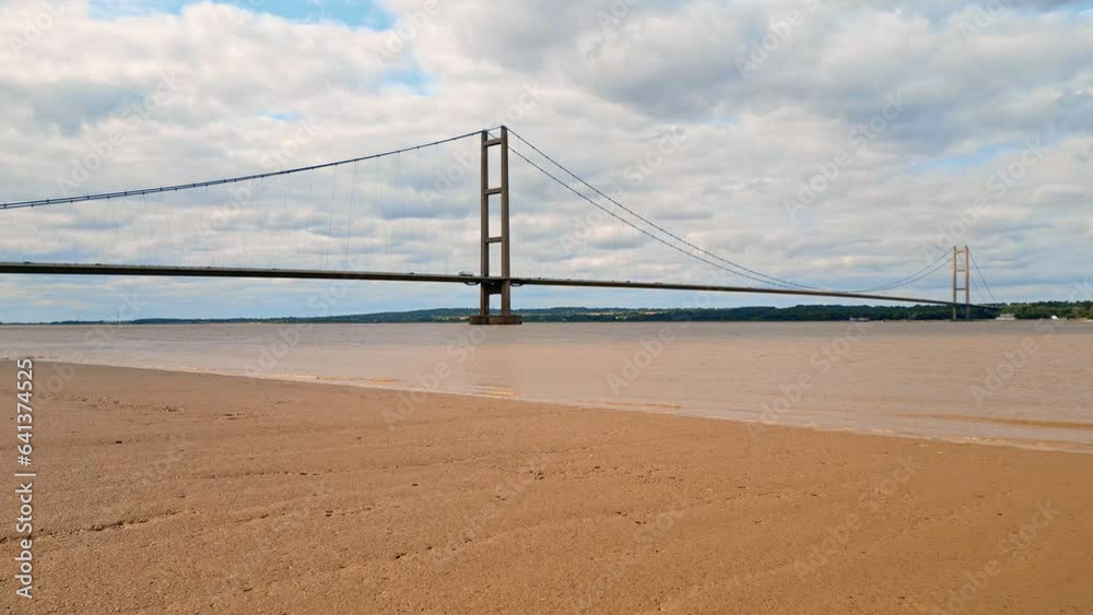 Aerial drone view of Humber Bridge, 12th largest suspension span, gracefully crossing River Humber, connecting Lincolnshire to Humberside with traffic. Aerial drone view of Humber Bridge, 12th largest suspension span, gracefully crossing River Humber, connecting Lincolnshire to Humberside with traffic.