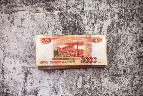 Stack of five thousand russian rubles much banknotes on stone textured backdrop, top view. Many bills banknotes 5000 ruble notes, one million cash money. Exchange currency concept. Copy ad text space