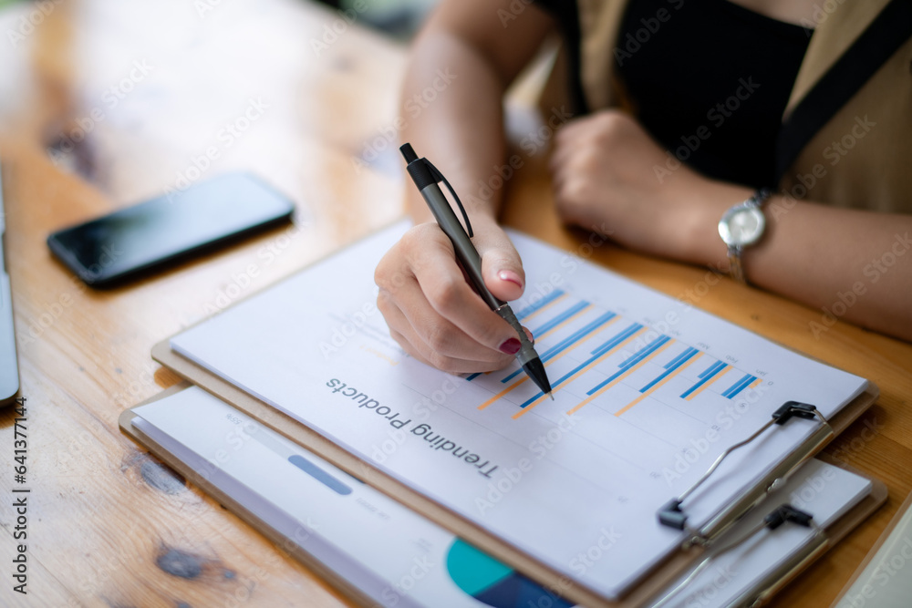 Cropped image of businesswoman analyzing business results by exploring trends of popular products in the market Cropped image of businesswoman analyzing business results by exploring trends of popular products in the market