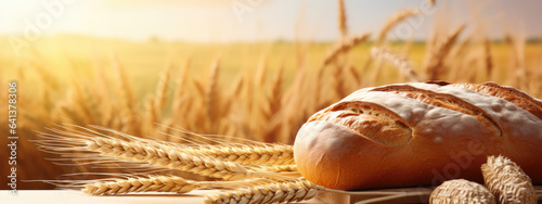 Fresh bread rests on a wooden surface against a field of wheat in the background