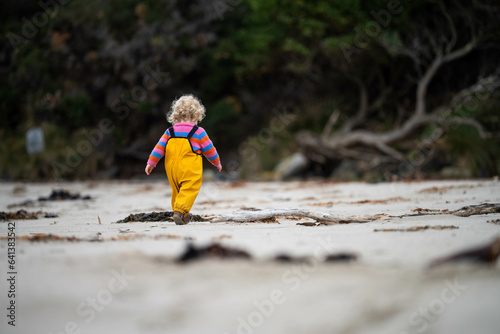 baby on the beach in yellow overalls