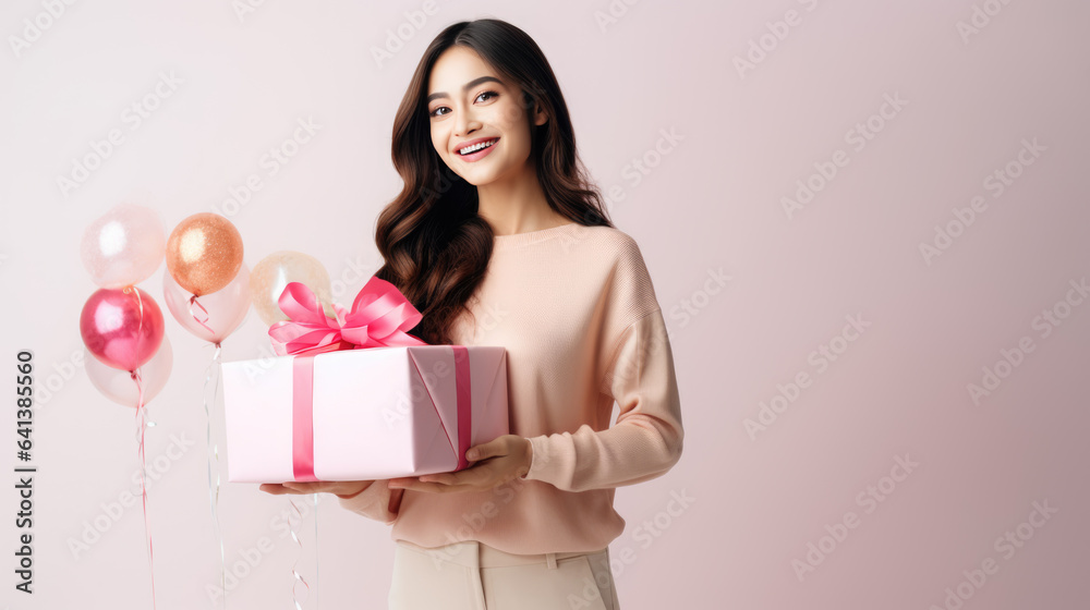Happy smiling woman holding gift box over pink background Happy smiling woman holding gift box over pink background