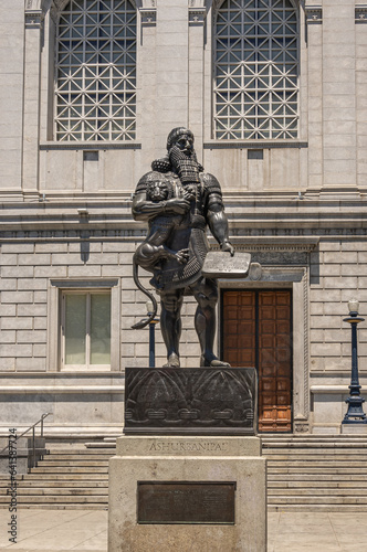 San Francisco, CA, USA - July 12, 2023: Statue of historic Ashurbanipal Assyrian king or Enkidu holding a wriggling lion and a tablet, at south facade of Asian Art Museum. photo