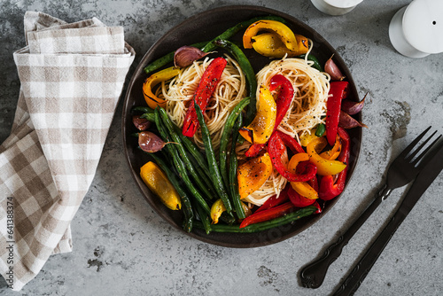 Plate of pasta with roasted  vegetables, green bean, red and yellow bell pepper, garlic photo