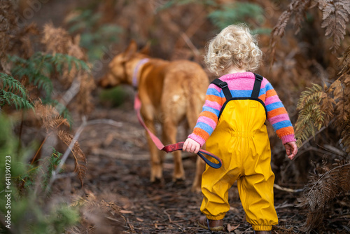 kid walking her dog on a lead on a path on a hike © William