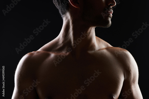 Topless, muscle and sexy man in black background for fitness inspiration, beauty aesthetic or healthy body. Shadow, torso of strong male model or bodybuilder in dark studio with art lighting for gym.