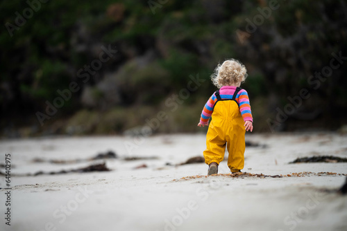 baby on the beach in yellow overalls