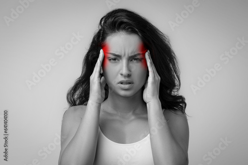 Irritated upset middle eastern millennial woman in pain rubbing temples photo