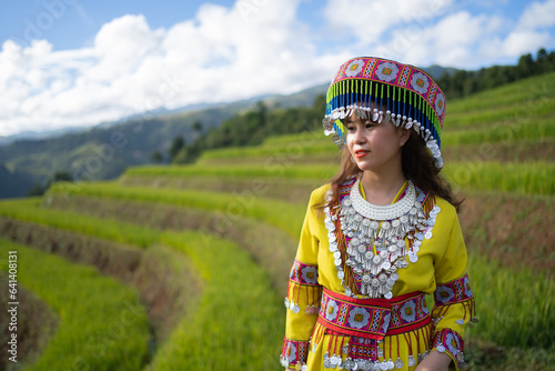 A farmer woman with fresh paddy rice terraces, green agricultural fields in countryside or rural area of Mu Cang Chai, mountain hills valley in Asia, Vietnam. Nature landscape. People lifestyle.