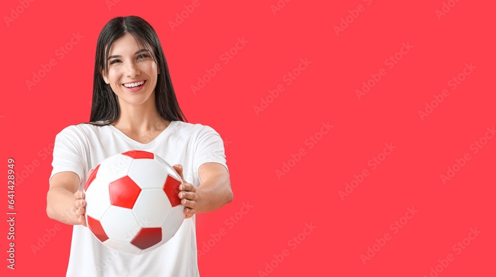 Happy young woman with soccer ball on red background with space for text Happy young woman with soccer ball on red background with space for text