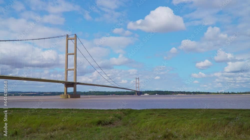 Aerial drone view of Humber Bridge, 12th largest suspension span, gracefully crossing River Humber, connecting Lincolnshire to Humberside with traffic. Aerial drone view of Humber Bridge, 12th largest suspension span, gracefully crossing River Humber, connecting Lincolnshire to Humberside with traffic.