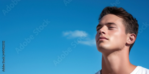 man's clean-shaven face, highlighting smooth skin and a youthful appearance against a sky-blue background, room for copyspace