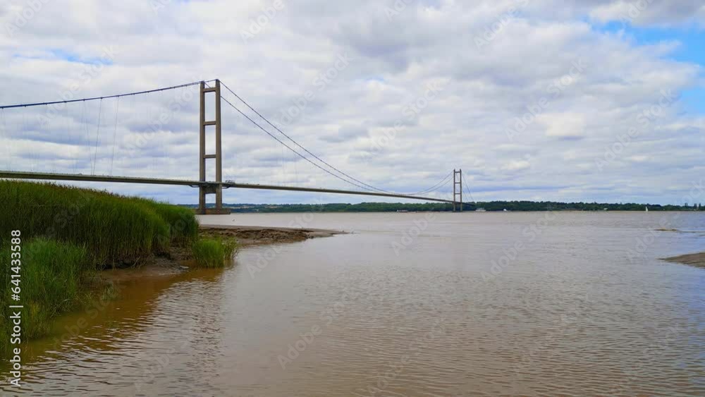 Aerial drone view of Humber Bridge, 12th largest suspension span, gracefully crossing River Humber, connecting Lincolnshire to Humberside with traffic. Aerial drone view of Humber Bridge, 12th largest suspension span, gracefully crossing River Humber, connecting Lincolnshire to Humberside with traffic.