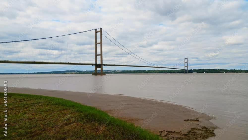 Aerial drone view of Humber Bridge, 12th largest suspension span, gracefully crossing River Humber, connecting Lincolnshire to Humberside with traffic. Aerial drone view of Humber Bridge, 12th largest suspension span, gracefully crossing River Humber, connecting Lincolnshire to Humberside with traffic.