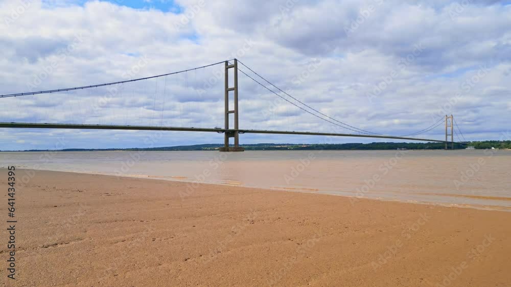 Aerial drone view of Humber Bridge, 12th largest suspension span, gracefully crossing River Humber, connecting Lincolnshire to Humberside with traffic. Aerial drone view of Humber Bridge, 12th largest suspension span, gracefully crossing River Humber, connecting Lincolnshire to Humberside with traffic.