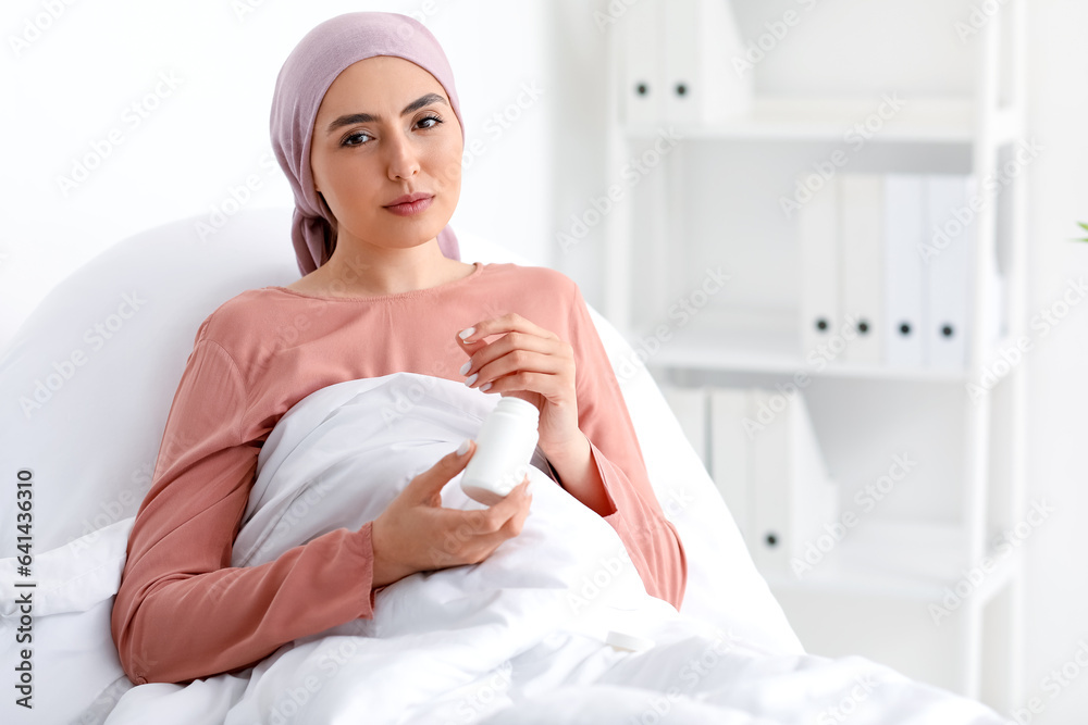 Young woman after chemotherapy with pills lying in clinic