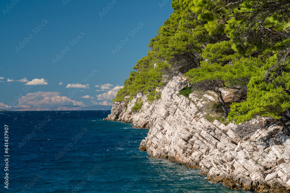 Amazing coastline. Mountains covered with greenery. Blue, transparent sea. Lonely lighthouse. Croatia, Makarska