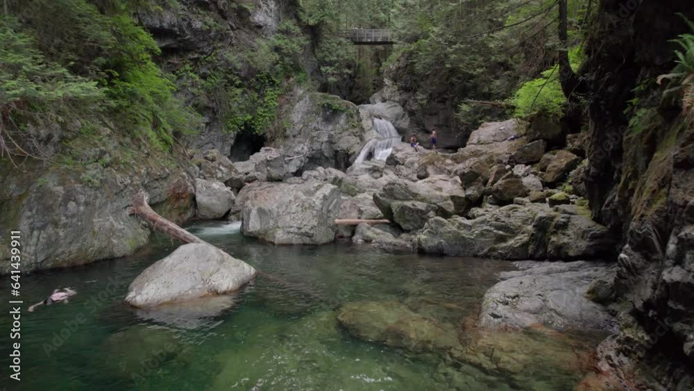 Friends cliff jumping and swimming in a crystal clear forest pool with a rushing waterfall, evergreen forest, turquoise, fresh water, nature. 4K 24FPS Friends cliff jumping and swimming in a crystal clear forest pool with a rushing waterfall, evergreen forest, turquoise, fresh water, nature. 4K 24FPS