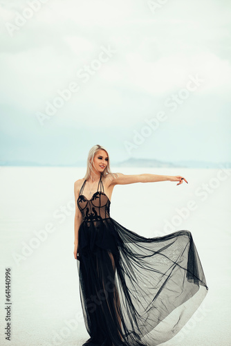 Beautiful blonde woman in a black dress at the Utah Salt Flats