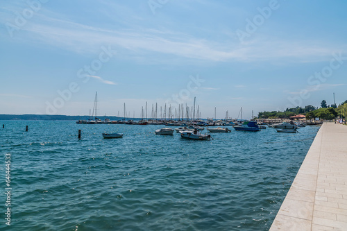 A view along the promenade towards boats moored at Portoroz, Slovenia in summertime © Nicola