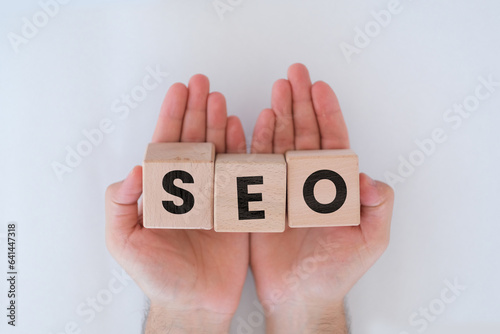 Wallpaper Mural Wooden block cubes with SEO text on man hands, website or search engine optimization idea, isolated on white background, SEO word on block cubes, banner design Torontodigital.ca